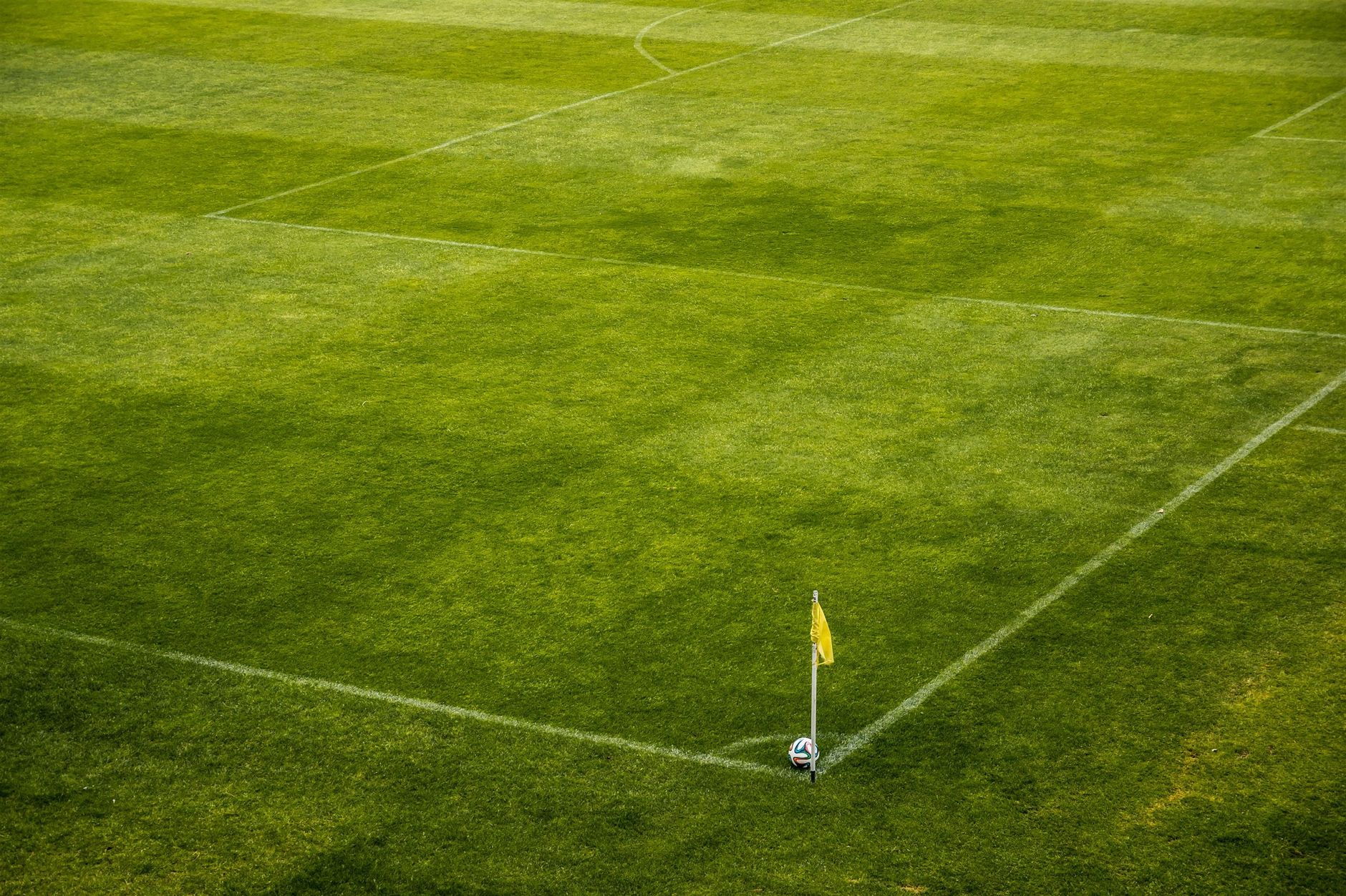 Ballon de football posé près d'un drapeau de corner sur la pelouse